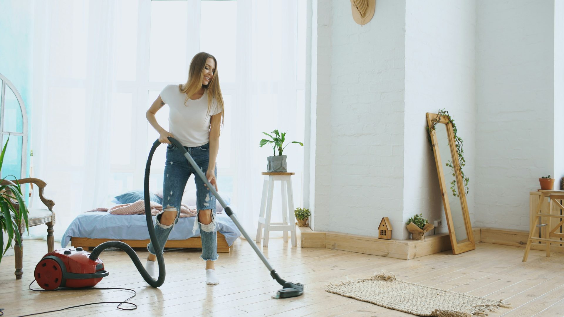 Eine Frau saugt ein helles, modernes Wohnzimmer